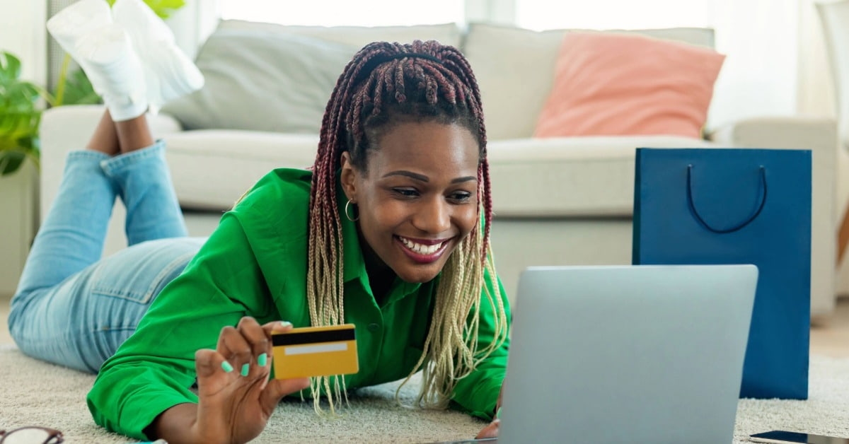 Mulher comprando online no notebook com cartão de crédito, ilustrando como vender sem estoque.
